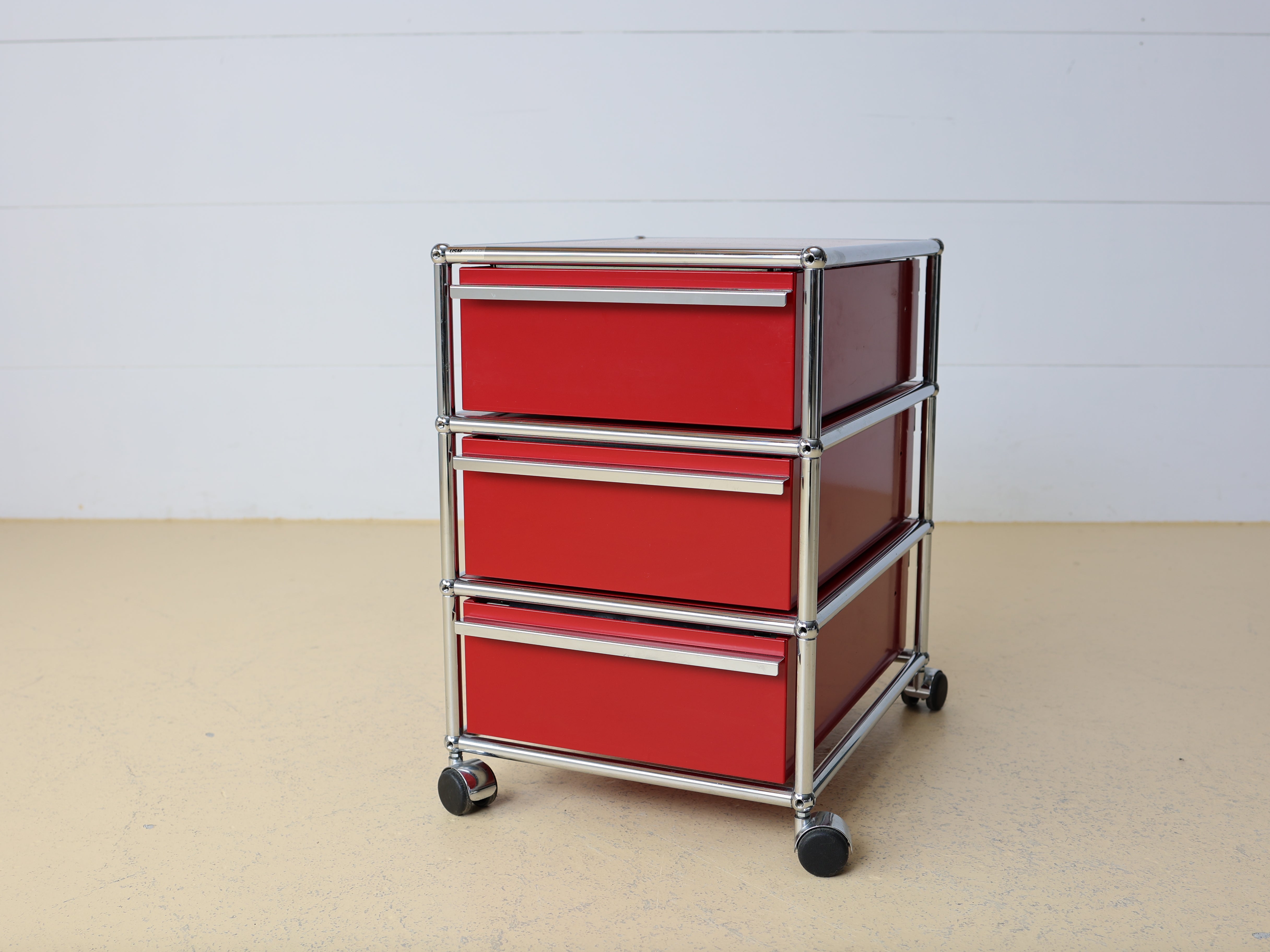 USM Haller Korpus Rubinrot auf Rollen