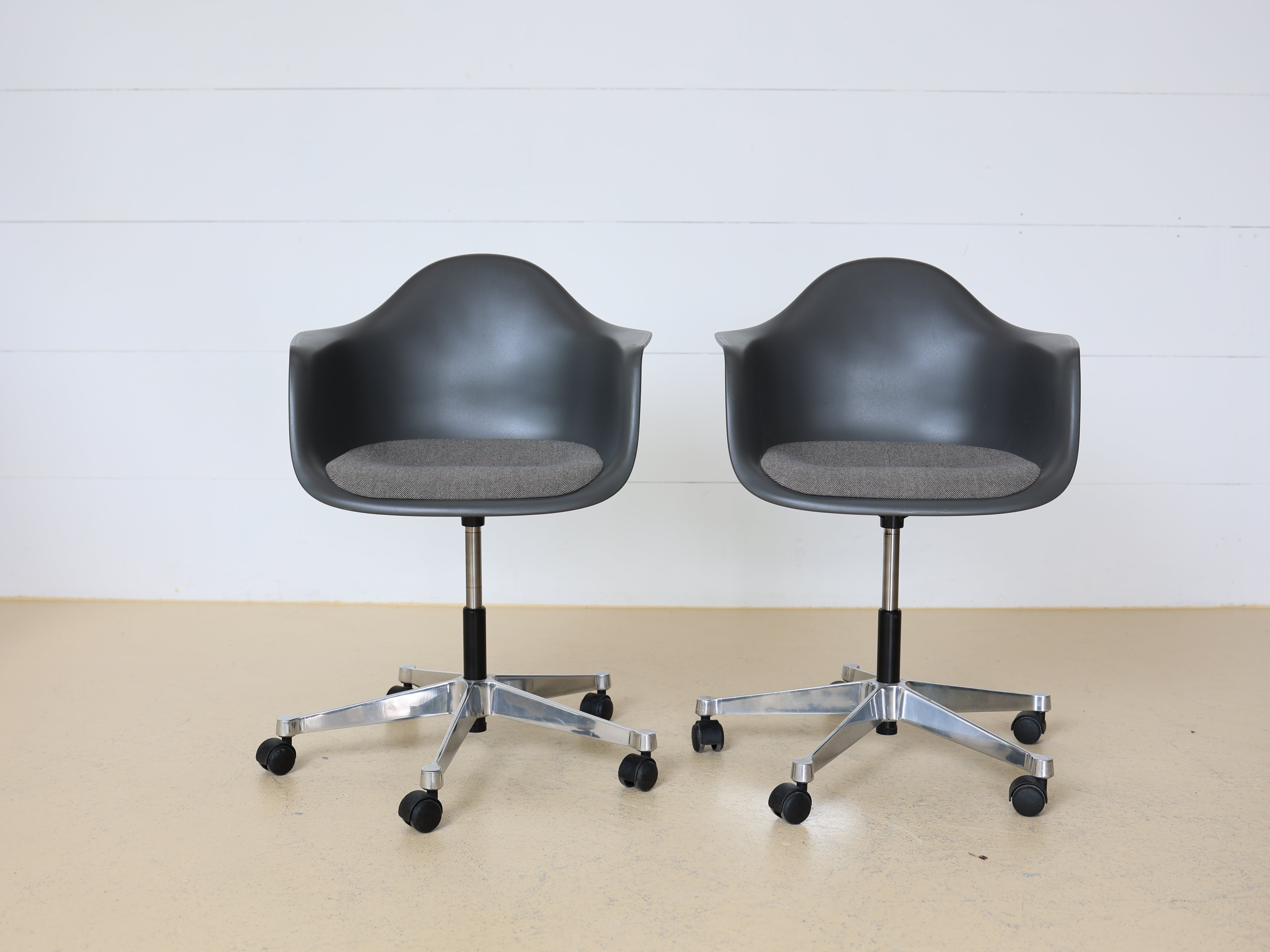 Vitra Charles & Ray Eames Plastic Armchair (PACC) Bürostuhl in Grau mit verchromtem Fünfsternuntergestell auf Rollen. Klassischer Design-Drehstuhl für das Home Office, erhältlich bei atelier TILIJA.