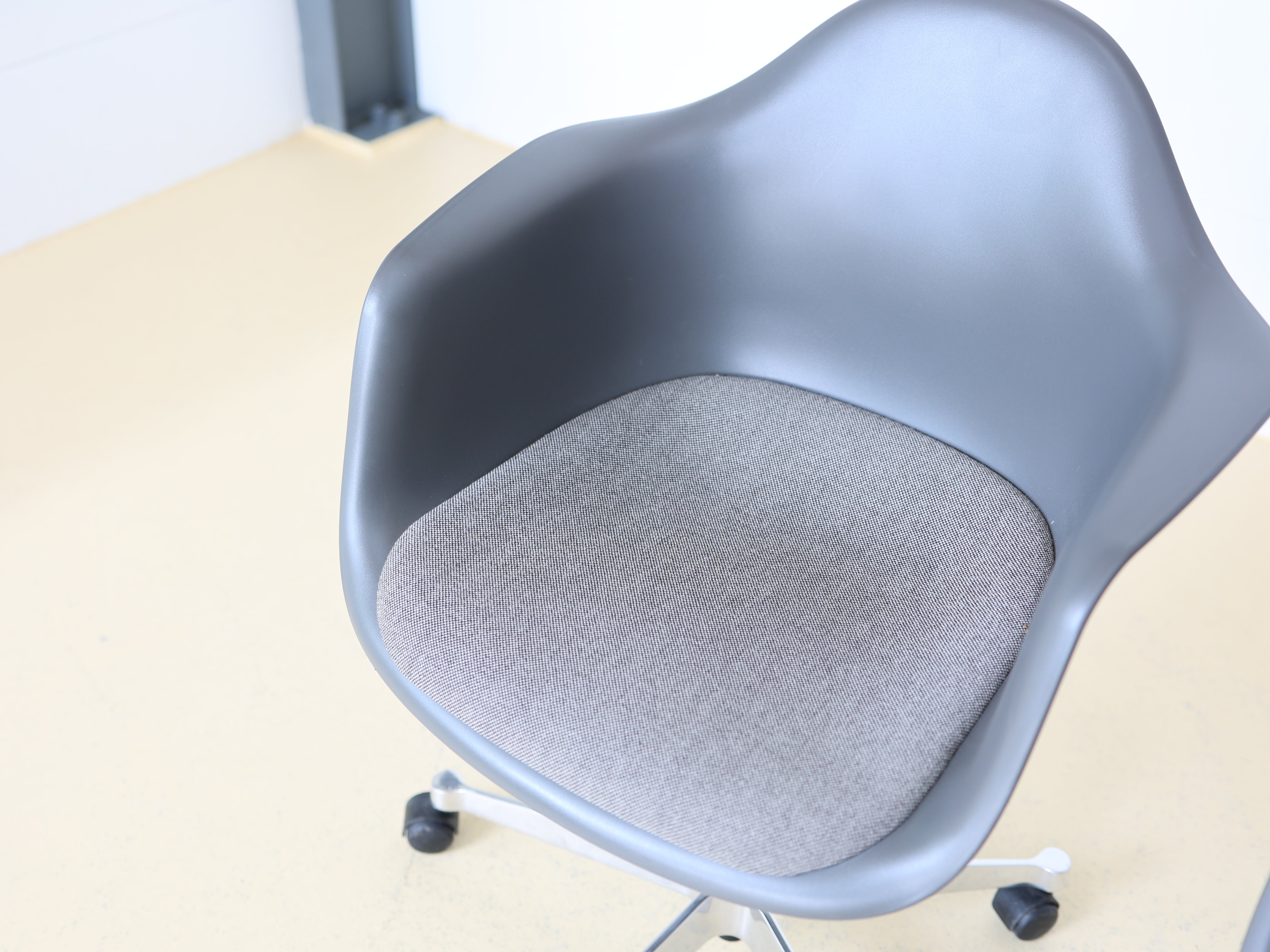 Vitra Charles & Ray Eames Plastic Armchair (PACC) Bürostuhl in Grau mit verchromtem Fünfsternuntergestell auf Rollen. Klassischer Design-Drehstuhl für das Home Office, erhältlich bei atelier TILIJA.