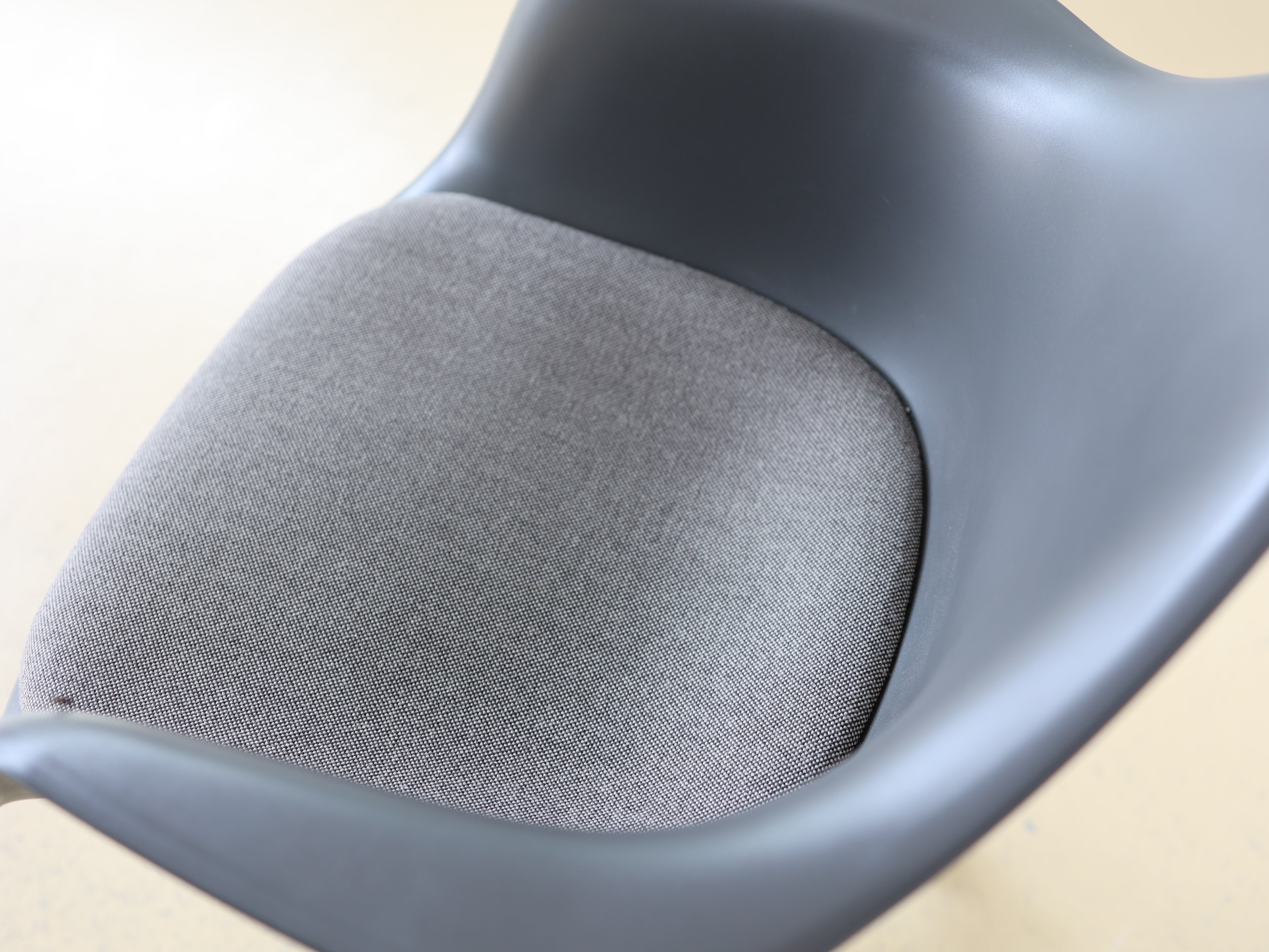 Vitra Charles & Ray Eames Plastic Armchair (PACC) Bürostuhl in Grau mit verchromtem Fünfsternuntergestell auf Rollen. Klassischer Design-Drehstuhl für das Home Office, erhältlich bei atelier TILIJA.