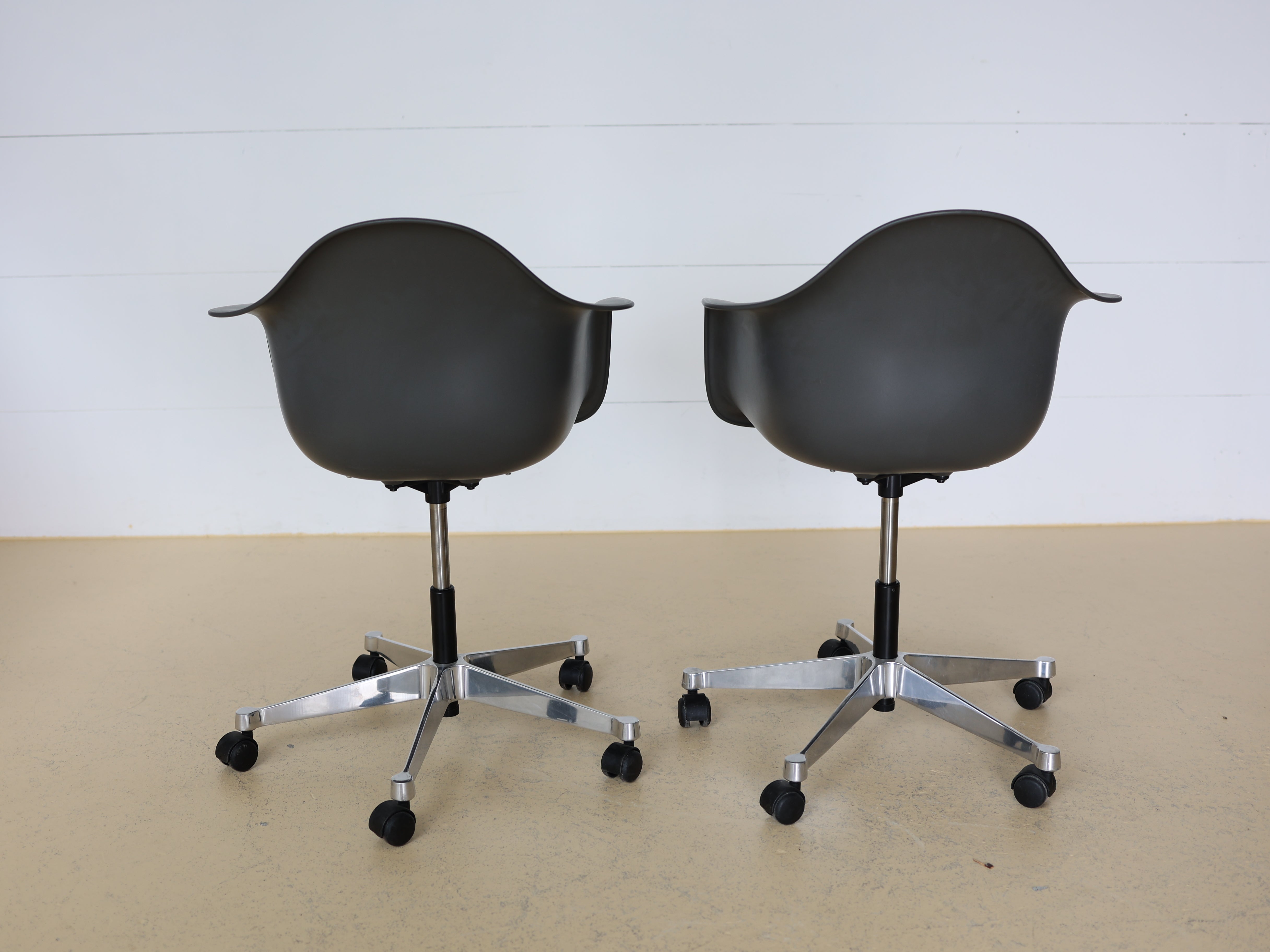 Vitra Charles & Ray Eames Plastic Armchair (PACC) Bürostuhl in Grau mit verchromtem Fünfsternuntergestell auf Rollen. Klassischer Design-Drehstuhl für das Home Office, erhältlich bei atelier TILIJA.