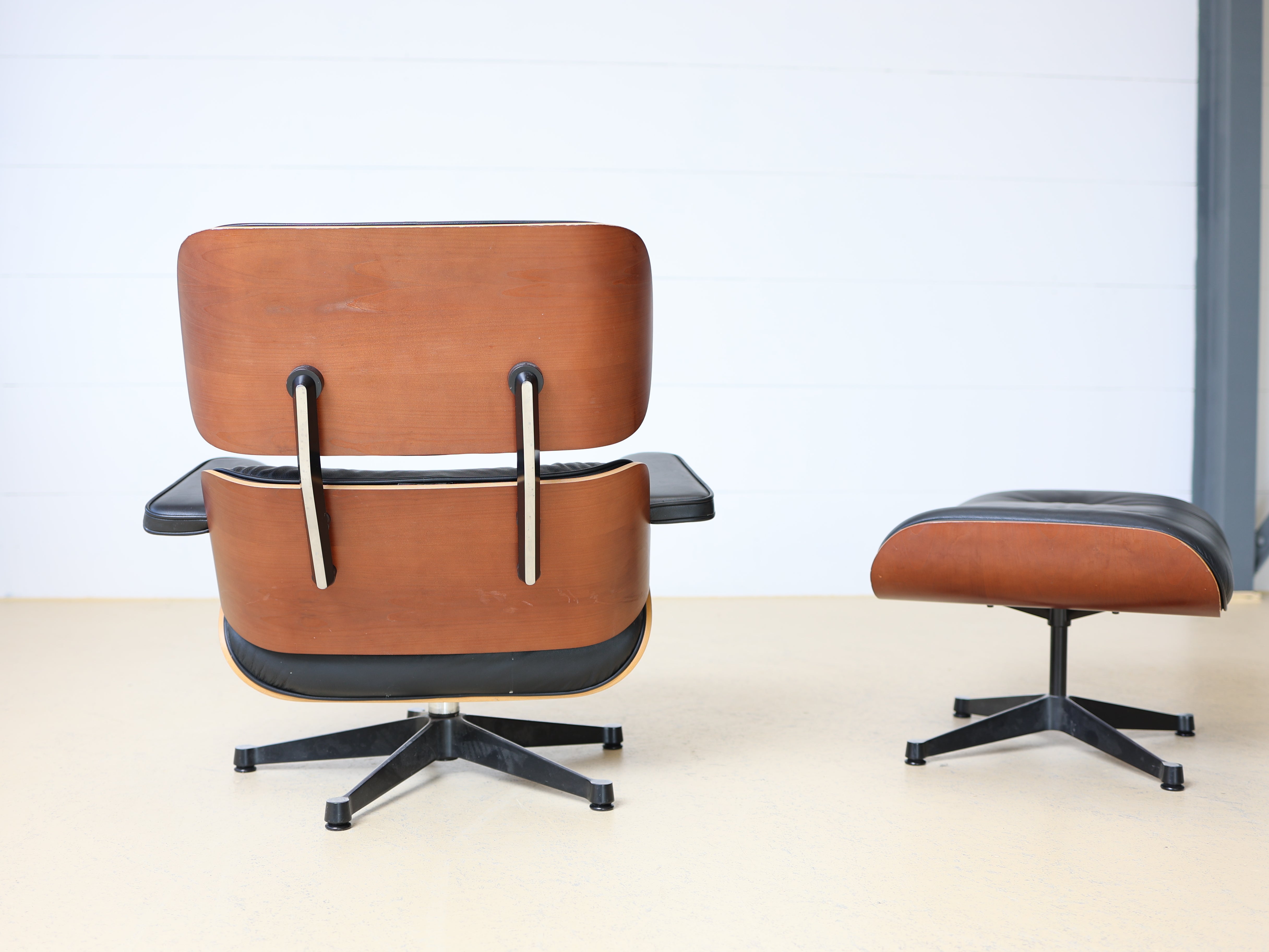 Original Vitra Eames Lounge Chair mit Ottoman in schwarzem Leder und Nussbaum-Holzschale. Der ultimative Designklassiker bei atelier TILIJA.