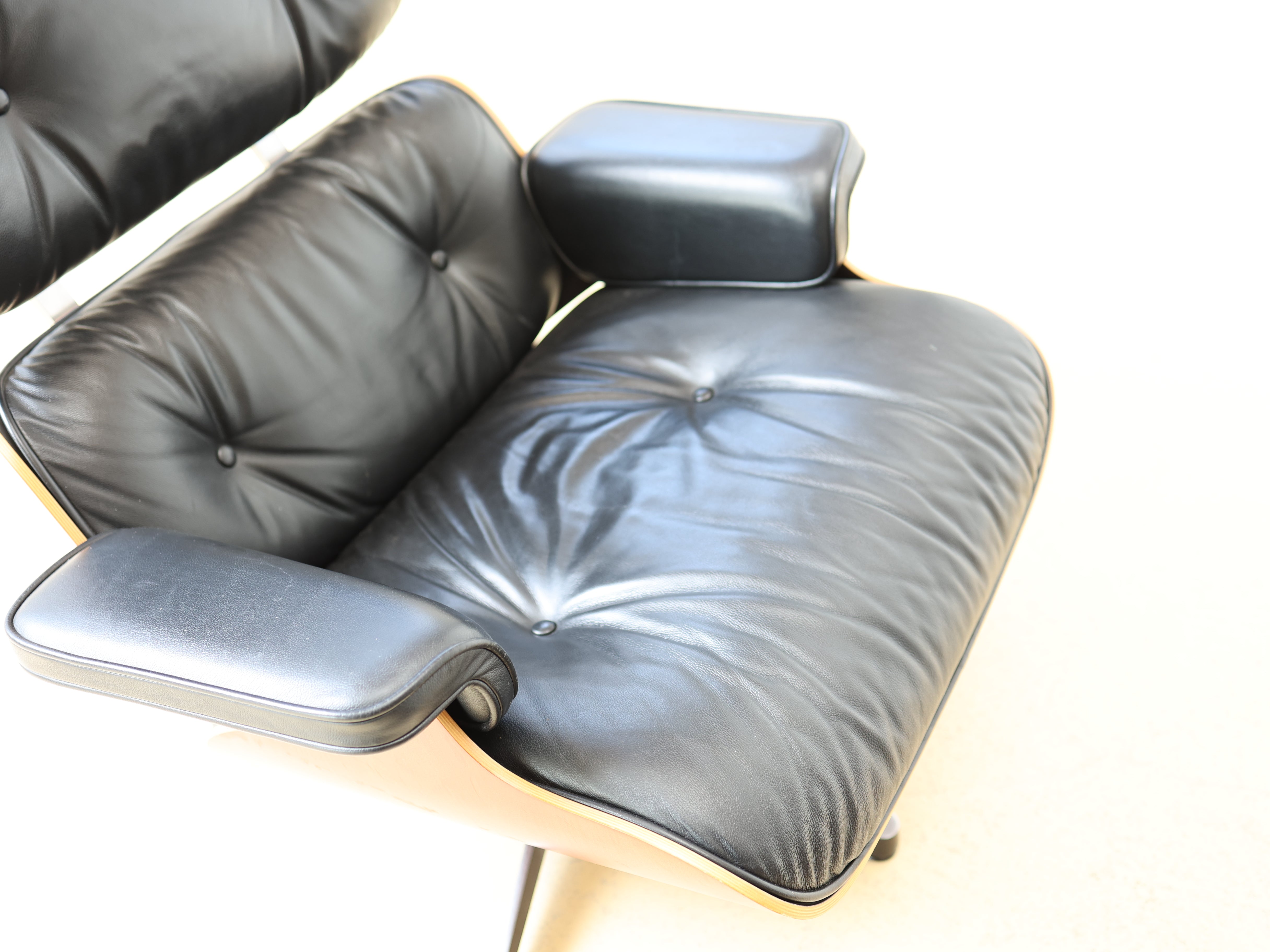 Original Vitra Eames Lounge Chair mit Ottoman in schwarzem Leder und Nussbaum-Holzschale. Der ultimative Designklassiker bei atelier TILIJA.