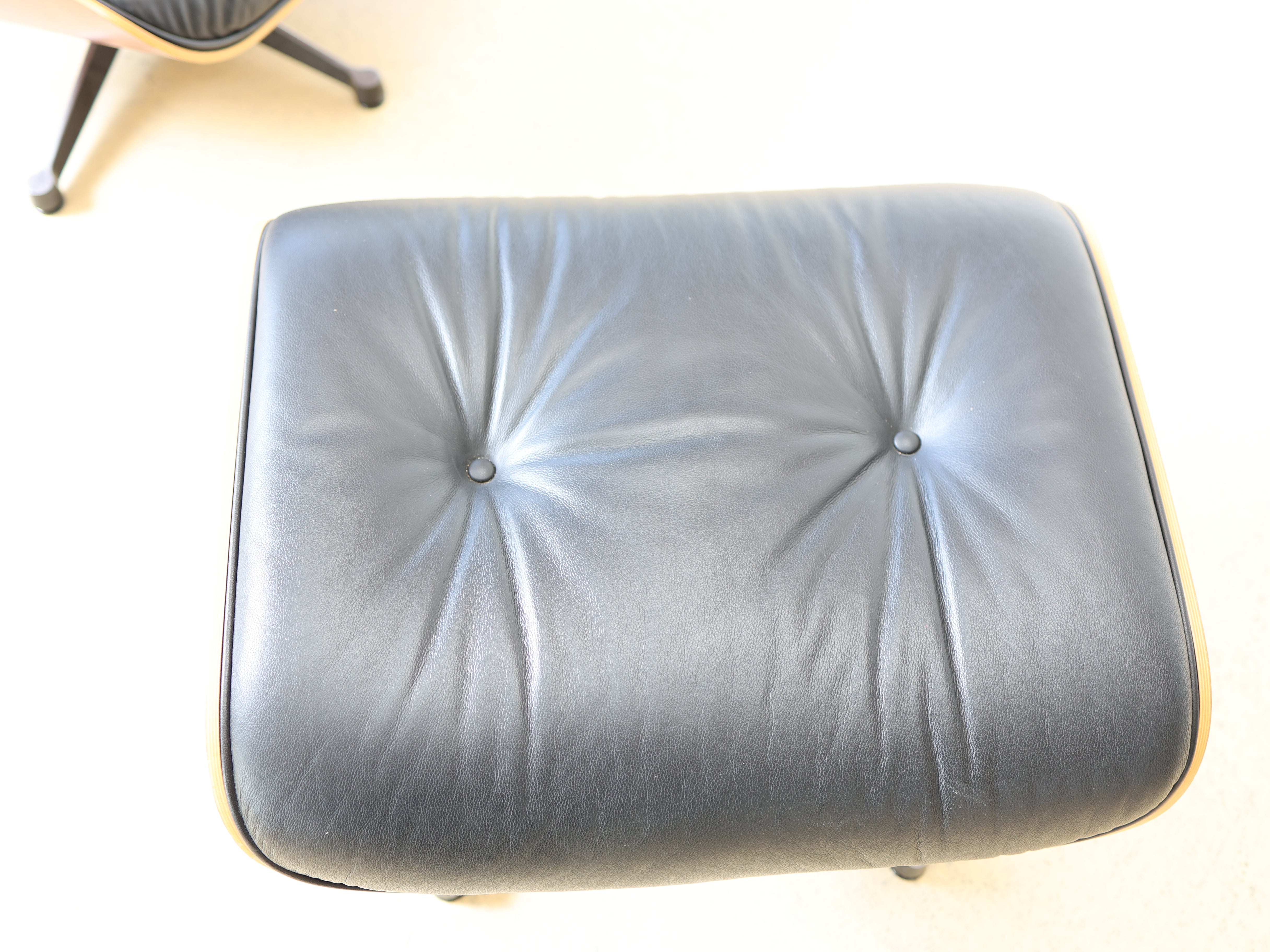 Original Vitra Eames Lounge Chair mit Ottoman in schwarzem Leder und Nussbaum-Holzschale. Der ultimative Designklassiker bei atelier TILIJA.
