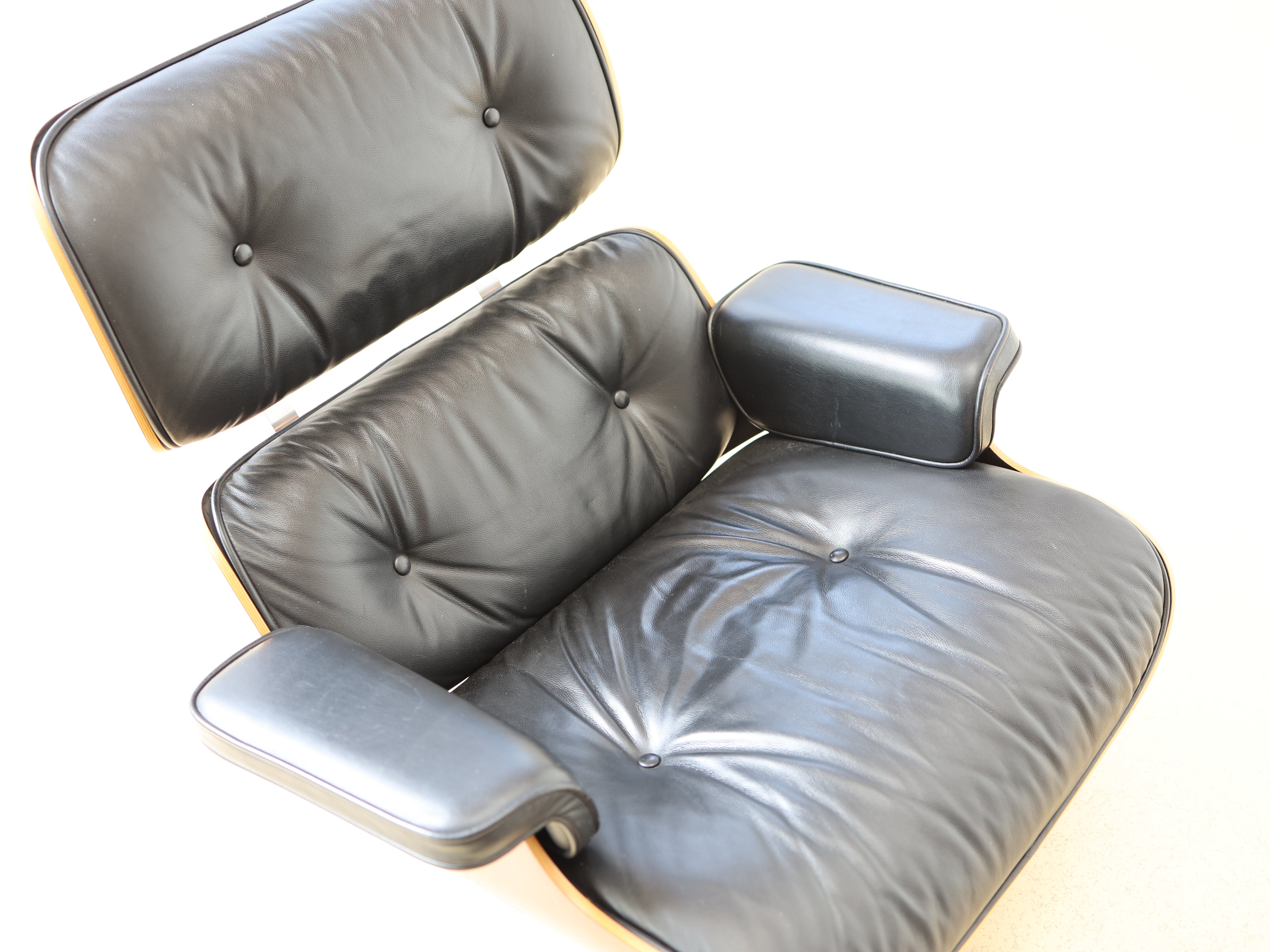 Original Vitra Eames Lounge Chair mit Ottoman in schwarzem Leder und Nussbaum-Holzschale. Der ultimative Designklassiker bei atelier TILIJA.