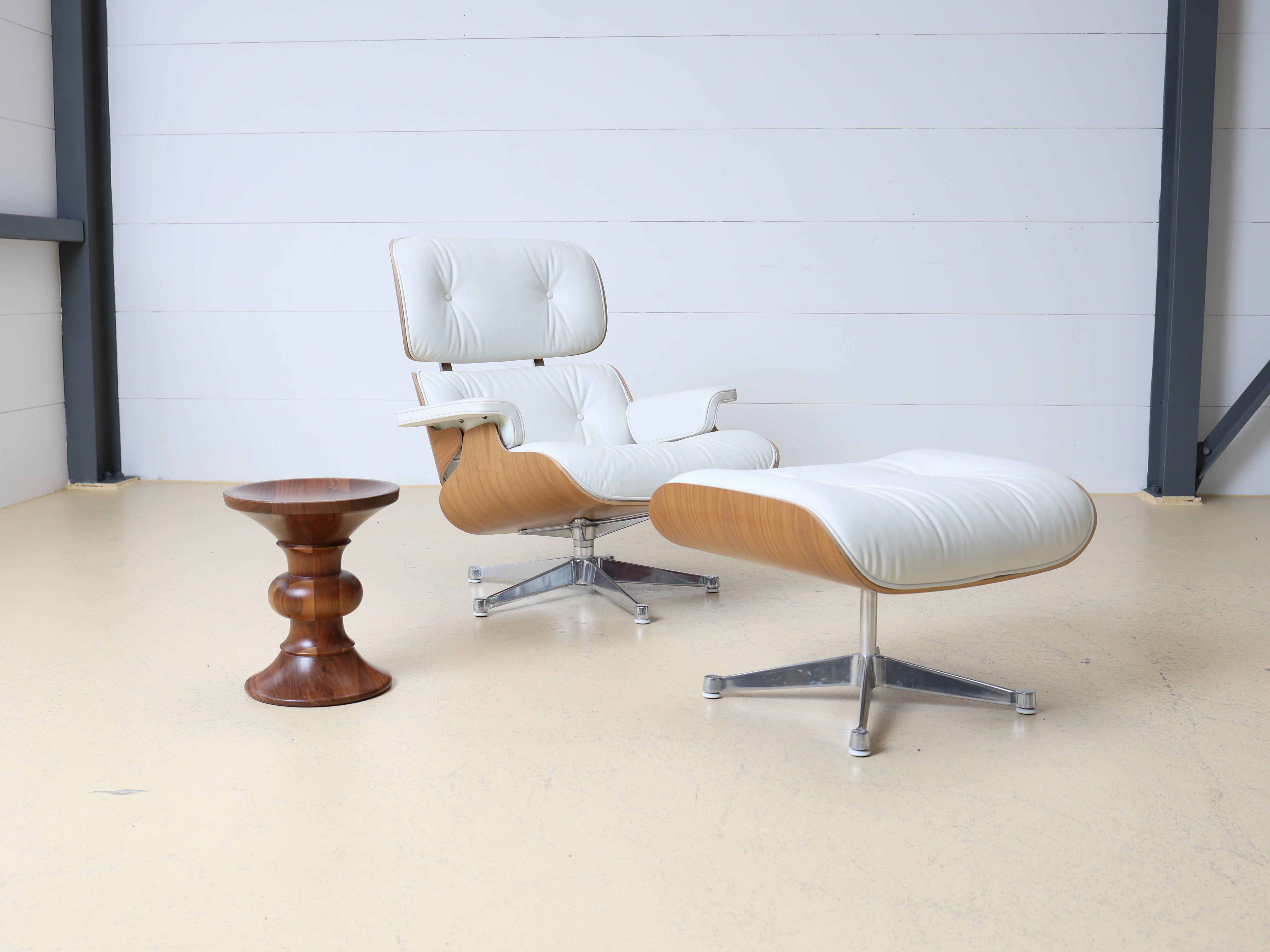 Original Vitra Eames Lounge Chair in weissem Leder und Nussbaum-Holzschale. Der ultimative Designklassiker bei atelier TILIJA.