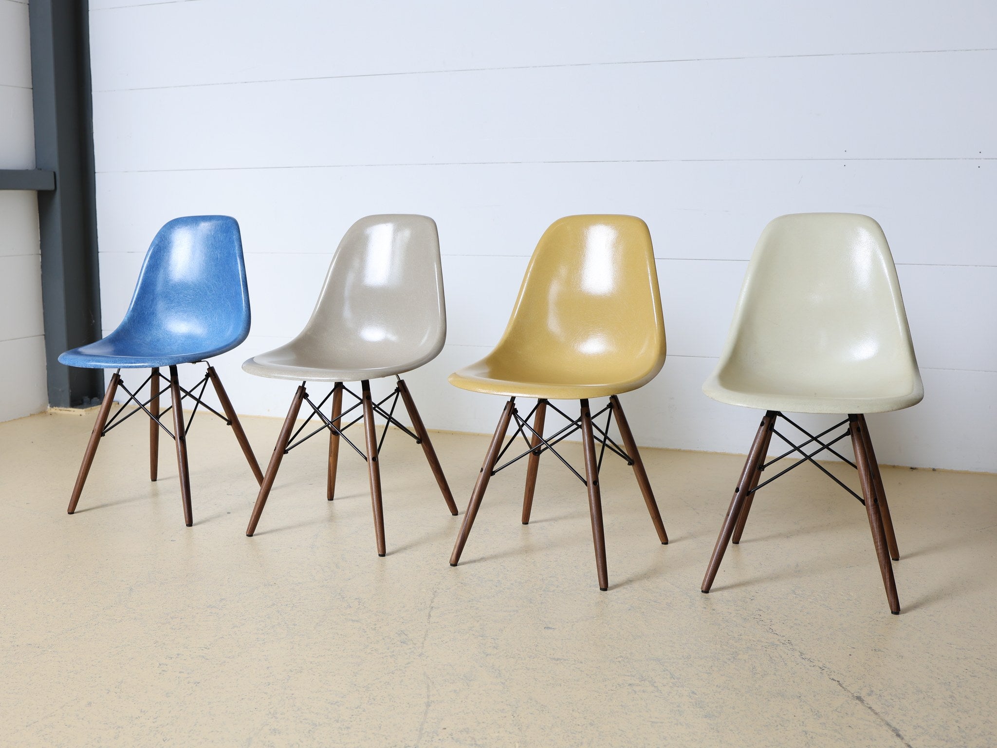 Vierer Set Eames DSW Chairs verschiedene Farben im Raum arrangiert