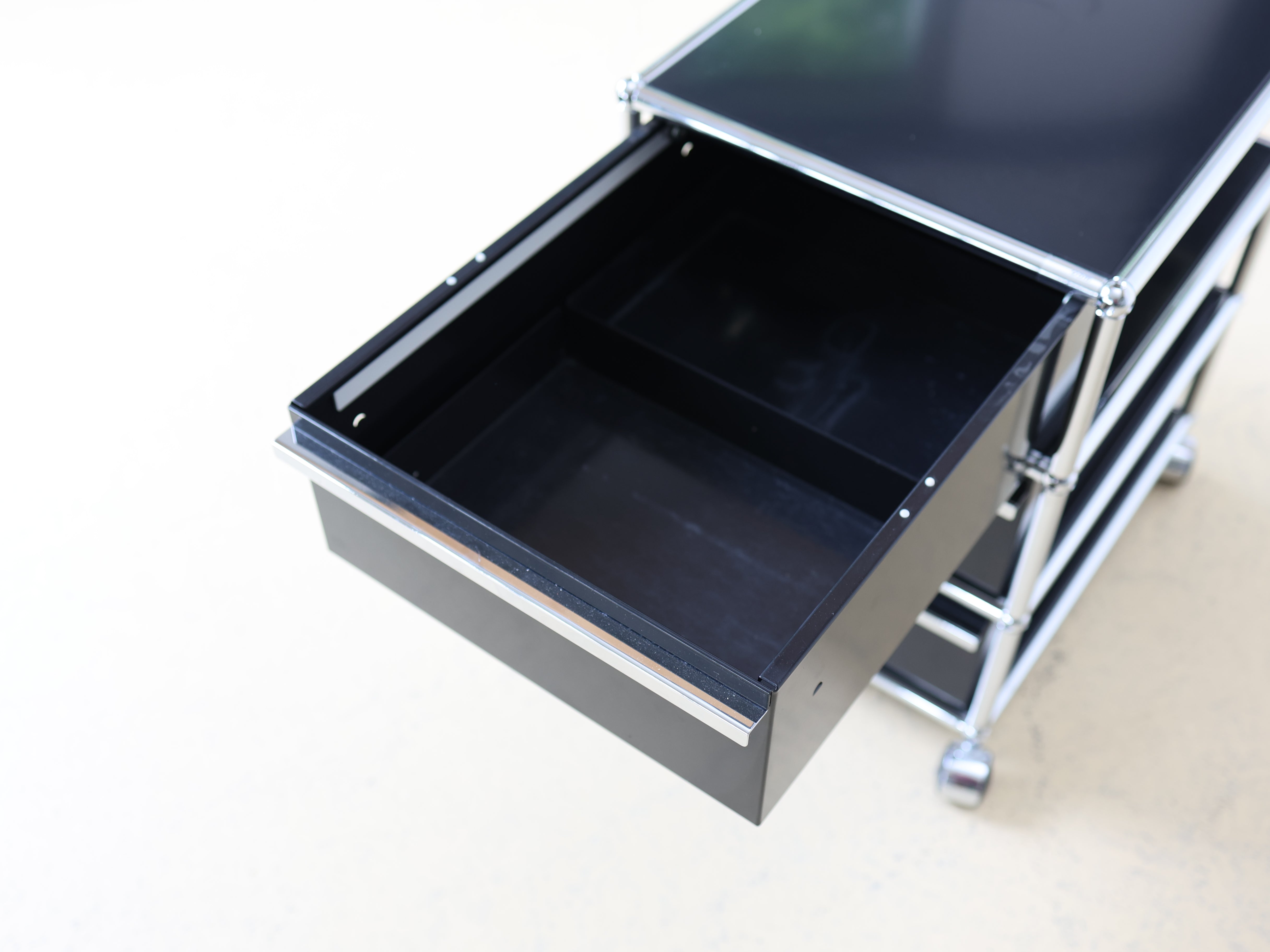 Schwarzer USM Haller Korpus und auf Rollen. Mobiler Bürocontainer als aufbereiteter und geprüfter Designklassiker bei atelier TILIJA.