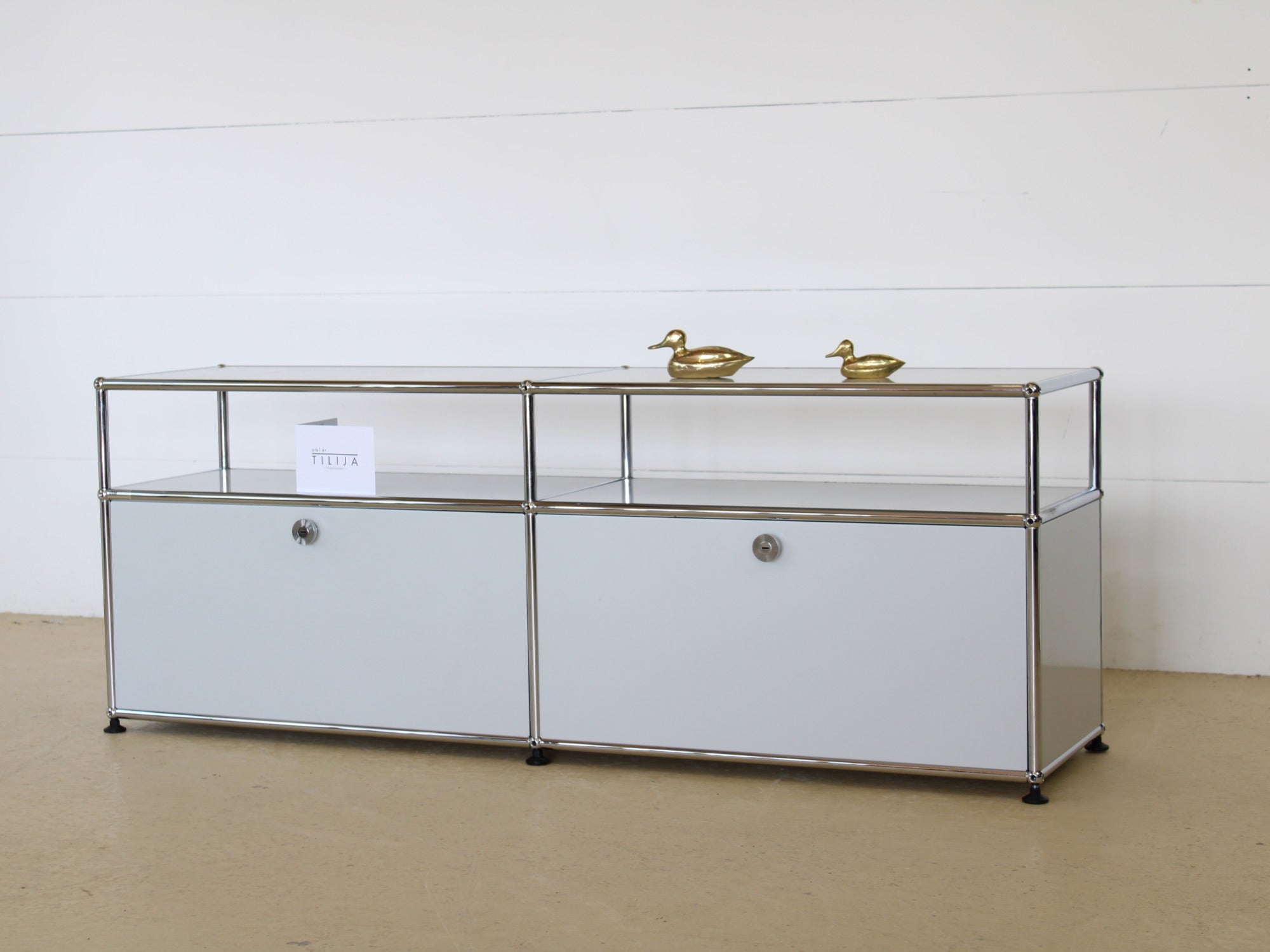 USM Haller Lowboard Vintage in Lichtgrau, mit zwei Klapptüren und 2 offen, tiefen Fächern. Modularer Schweizer Designklassiker im gepflegten Vintage-Zustand bei Atelier Tilija.