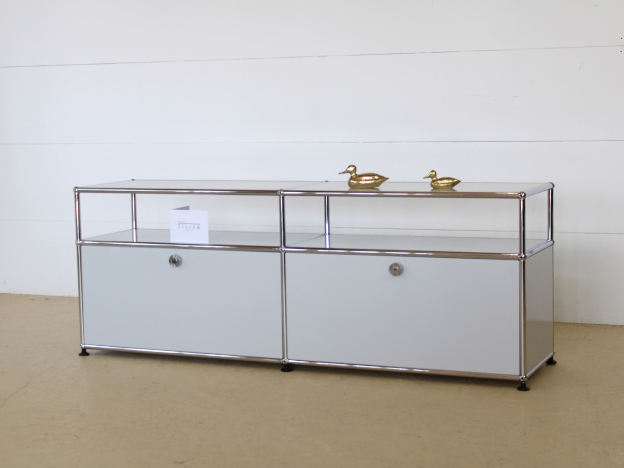 USM Haller Lowboard Vintage in Lichtgrau, mit zwei Klapptüren und 2 offen, tiefen Fächern. Modularer Schweizer Designklassiker im gepflegten Vintage-Zustand bei Atelier Tilija.