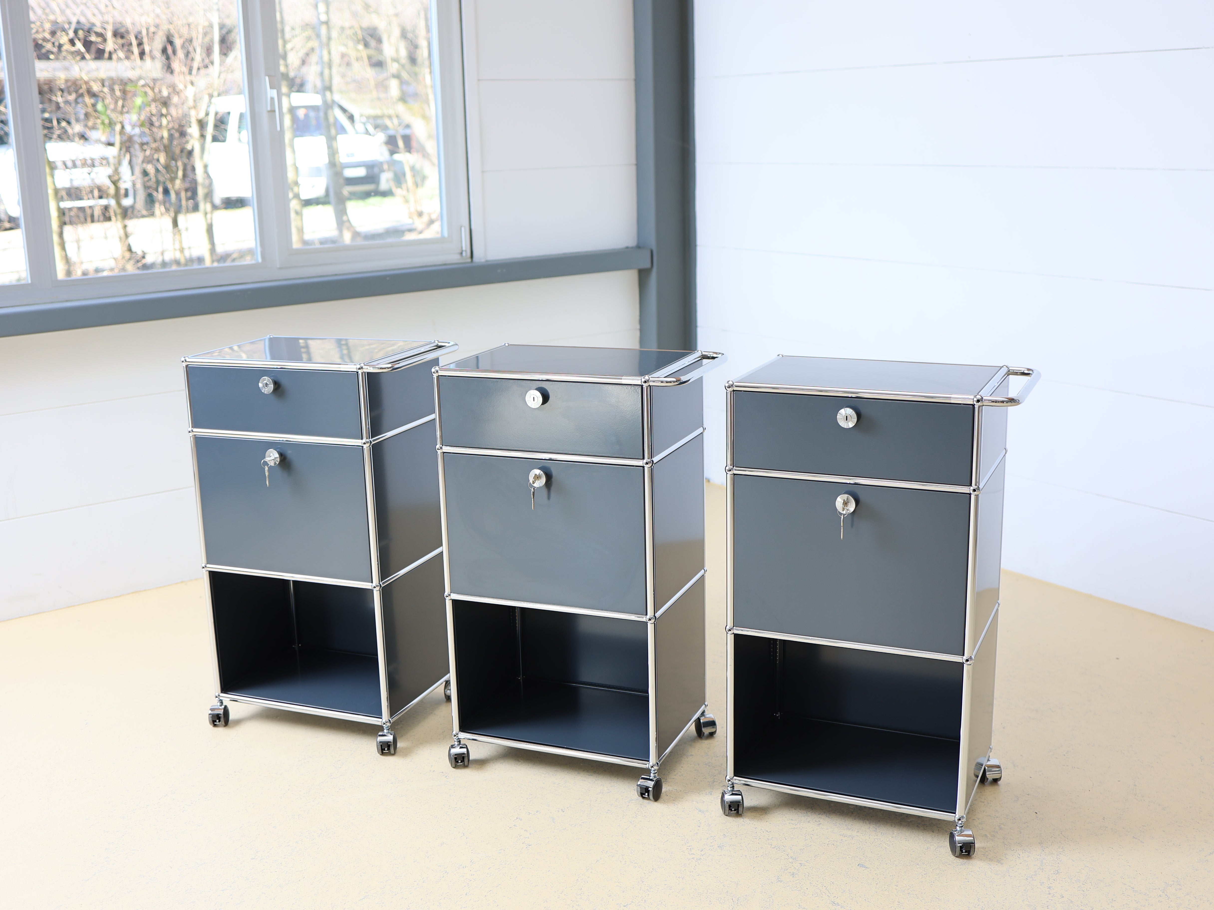 Anthrazitgrauer USM Haller Trolley auf Rollen mit Griff. Ein vielseitiger Servierboy oder Barwagen als aufbereiteter Designklassiker bei atelier TILIJA.