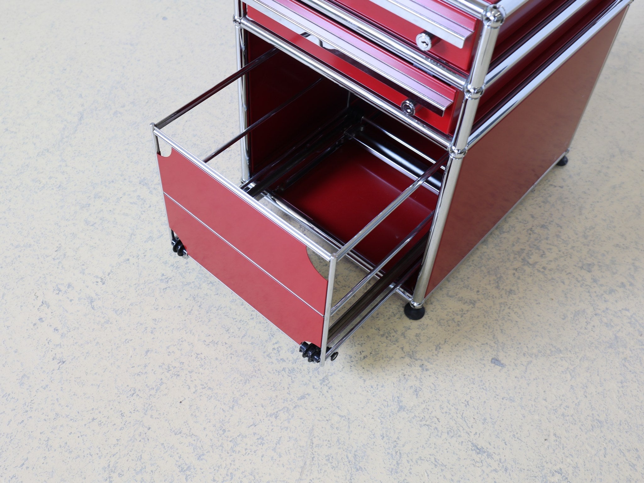 USM Haller Rollcontainer Rubinrot geöffnete Schublade mit Schloss Detail
