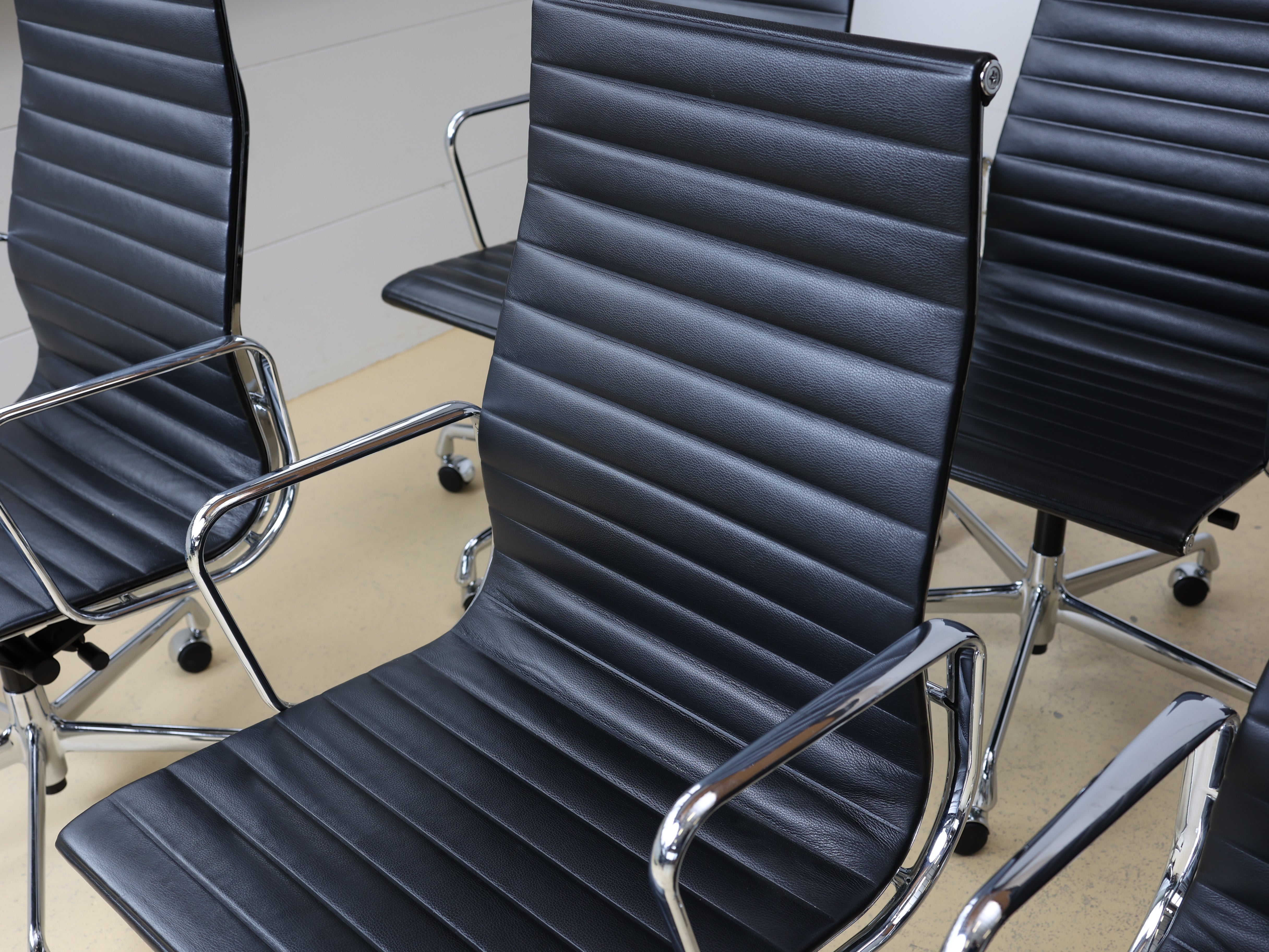 Vitra Eames Aluminium Chair EA 119 in schwarzem Leder mit hoher Rückenlehne. Ein repräsentativer Bürostuhl-Klassiker, Vintage in Top Qualität bei atelier TILIJA.