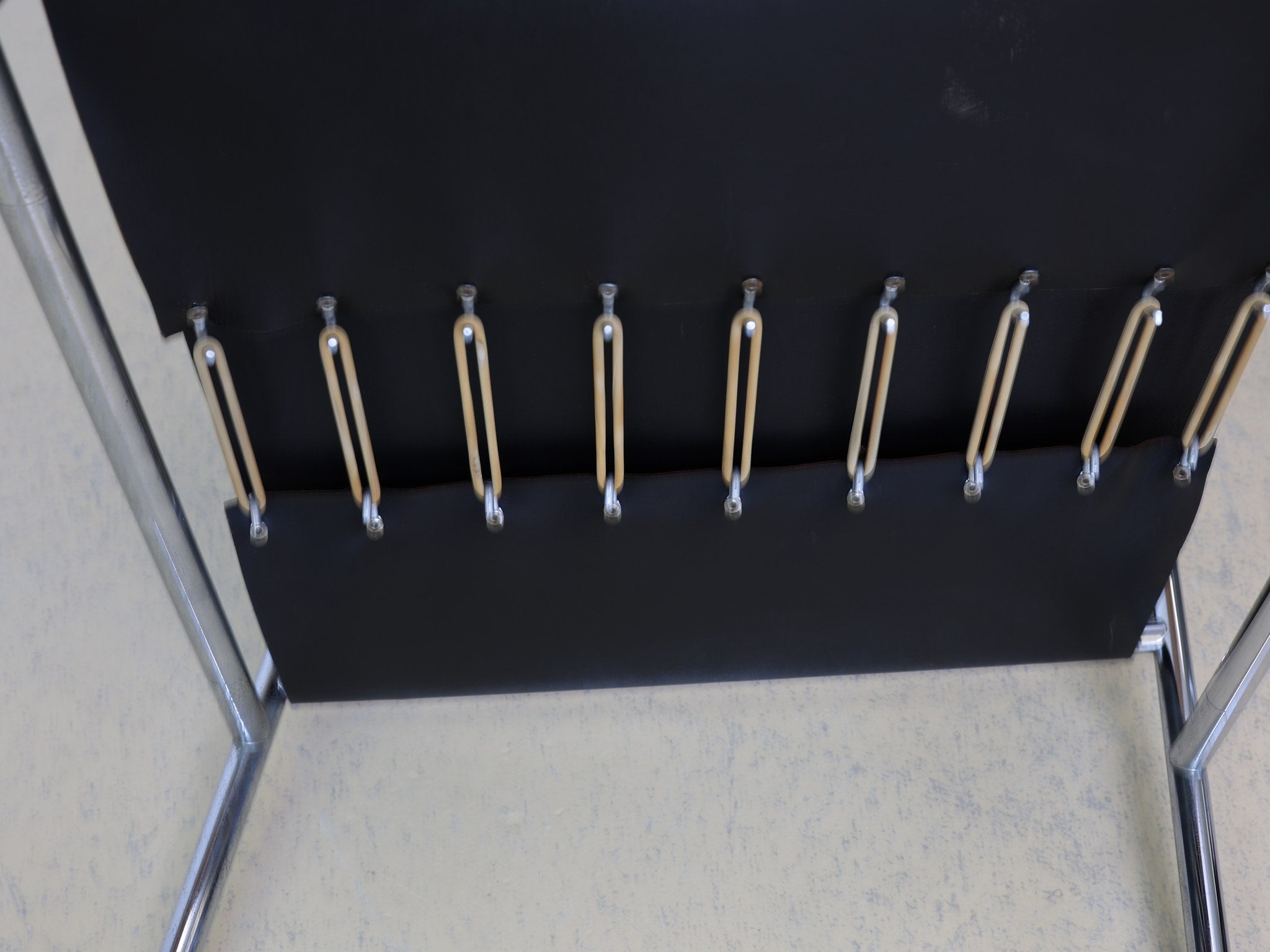 Detailaufnahme der originalen Gummispanner mit Metallhaken am Cassina LC1 Basculant