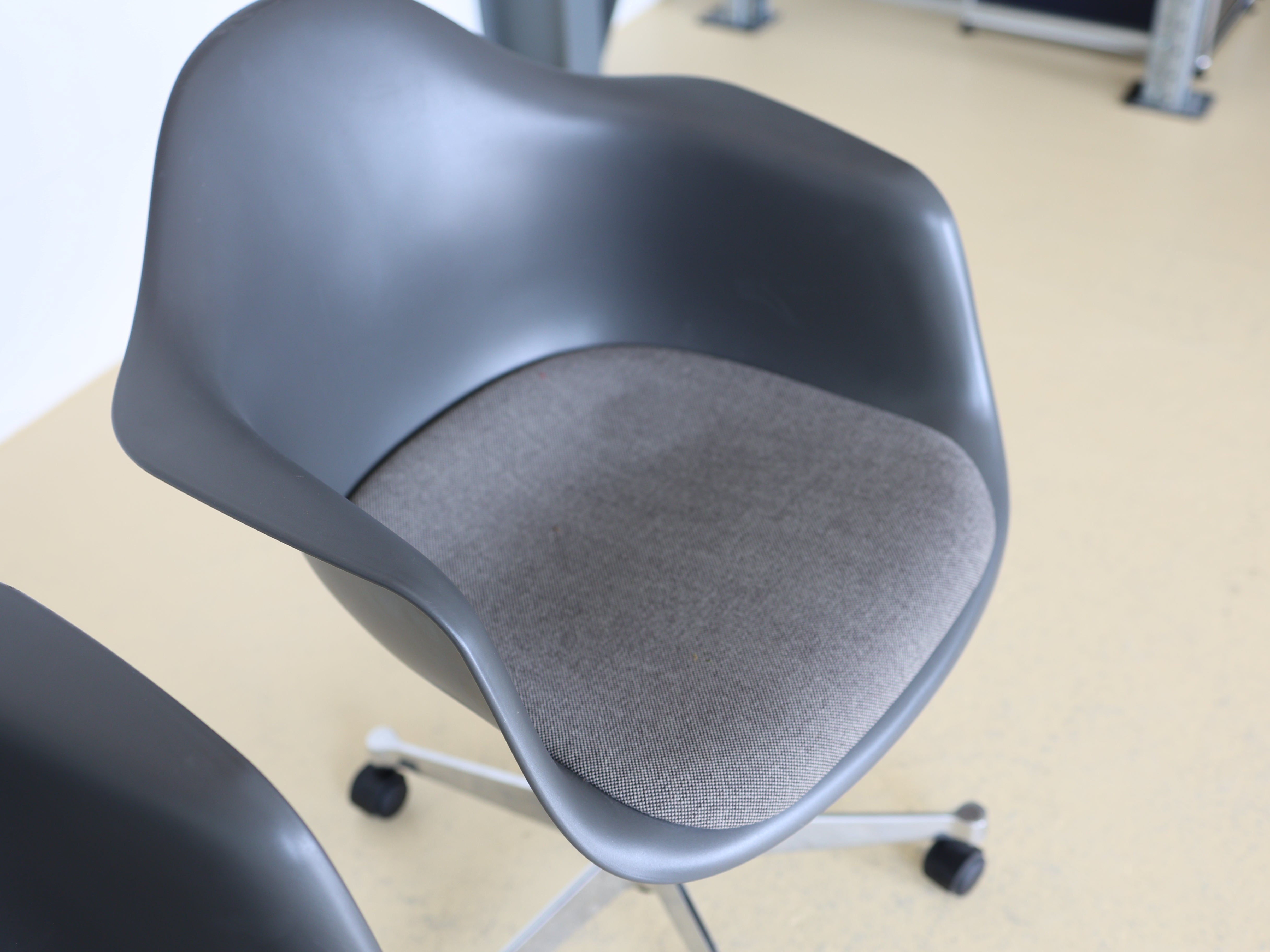 Vitra Charles & Ray Eames Plastic Armchair (PACC) Bürostuhl in Grau mit verchromtem Fünfsternuntergestell auf Rollen. Klassischer Design-Drehstuhl für das Home Office, erhältlich bei atelier TILIJA.