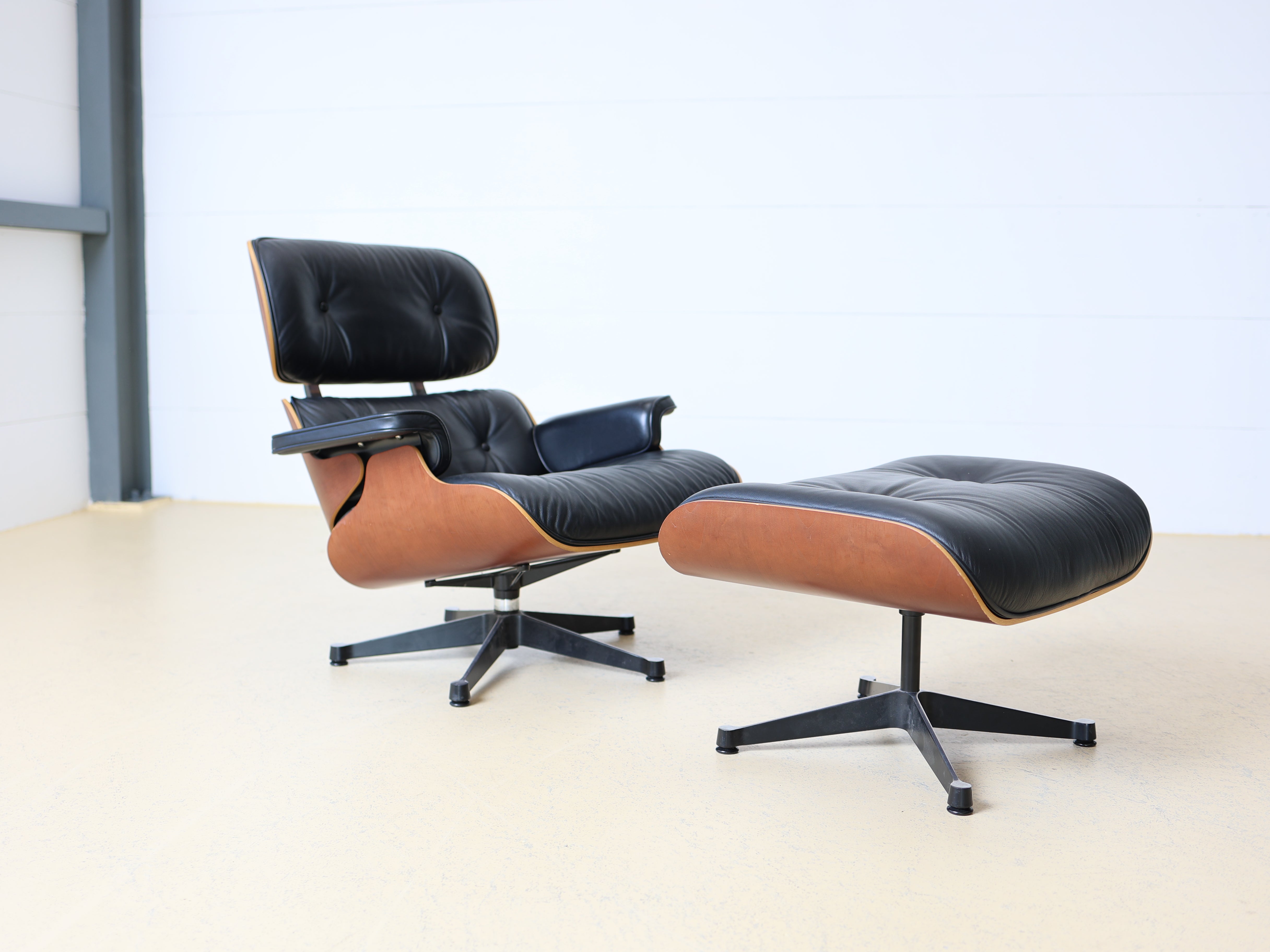 Original Vitra Eames Lounge Chair mit Ottoman in schwarzem Leder und Nussbaum-Holzschale. Der ultimative Designklassiker bei atelier TILIJA.