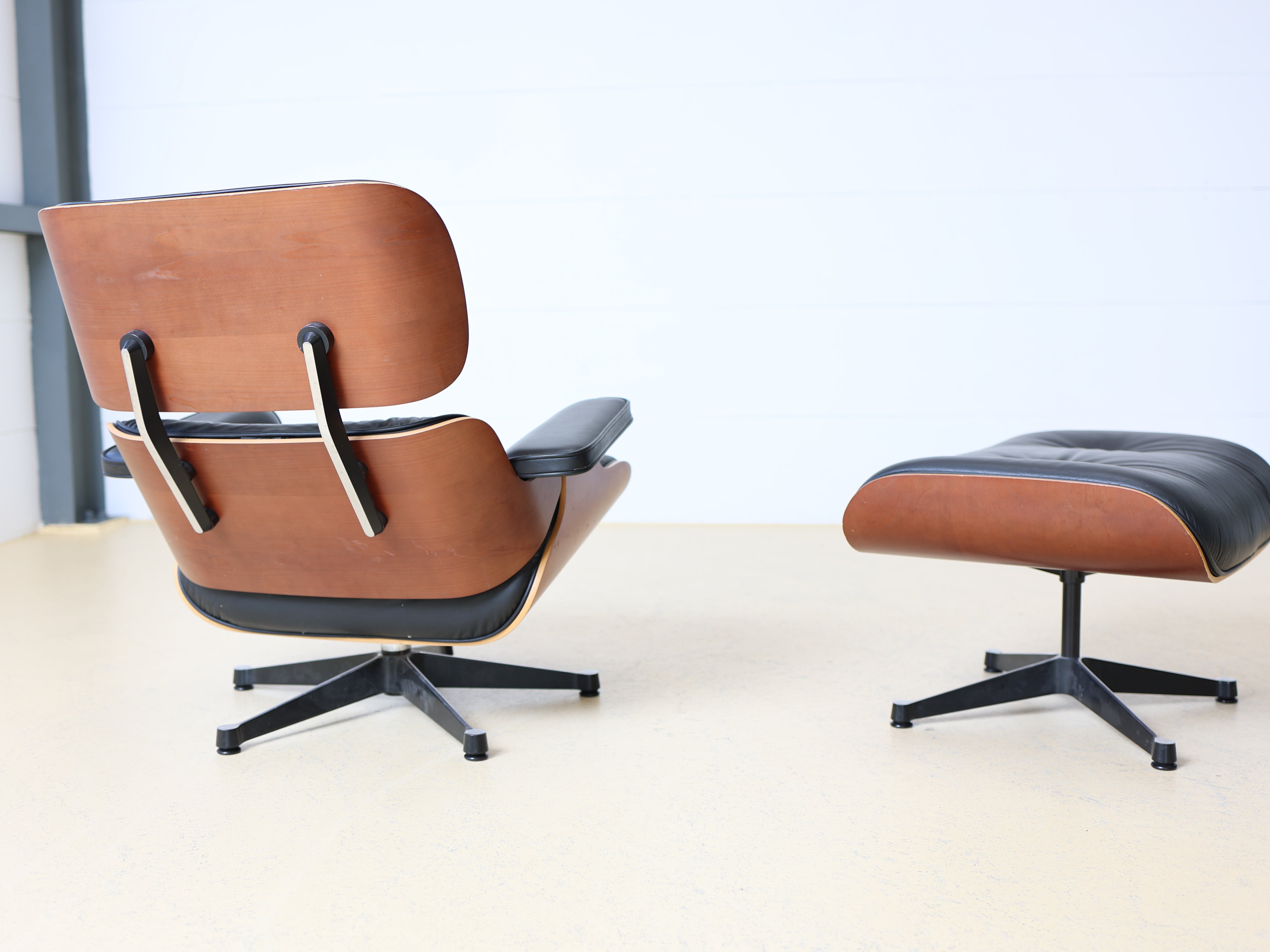 Original Vitra Eames Lounge Chair mit Ottoman in schwarzem Leder und Nussbaum-Holzschale. Der ultimative Designklassiker bei atelier TILIJA.