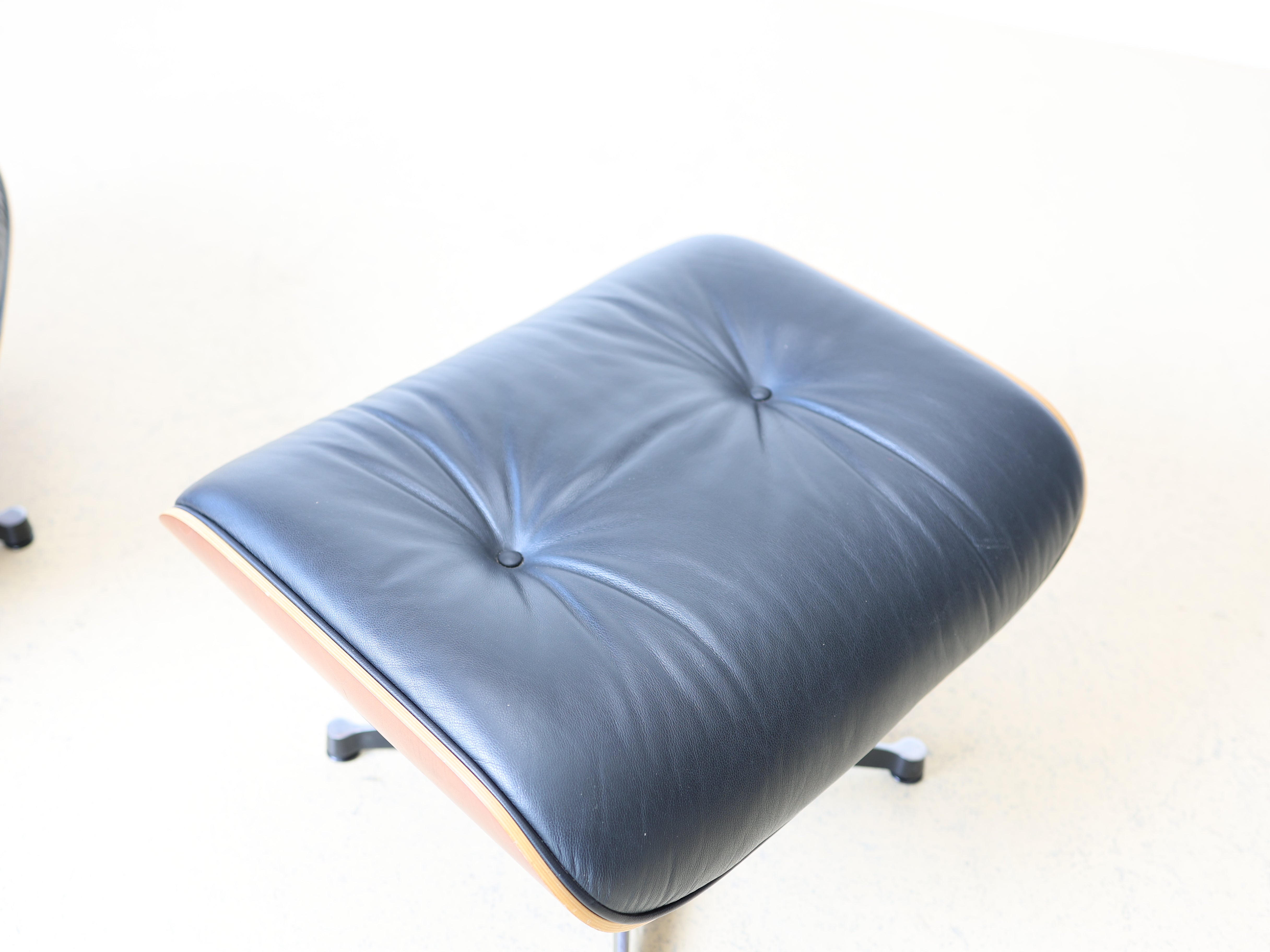 Original Vitra Eames Lounge Chair mit Ottoman in schwarzem Leder und Nussbaum-Holzschale. Der ultimative Designklassiker bei atelier TILIJA.