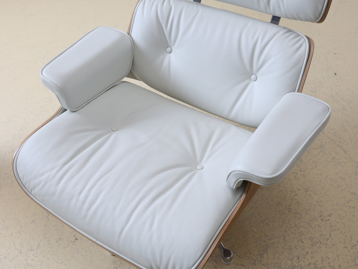 Original Vitra Eames Lounge Chair in weissem Leder und Nussbaum-Holzschale. Der ultimative Designklassiker bei atelier TILIJA.