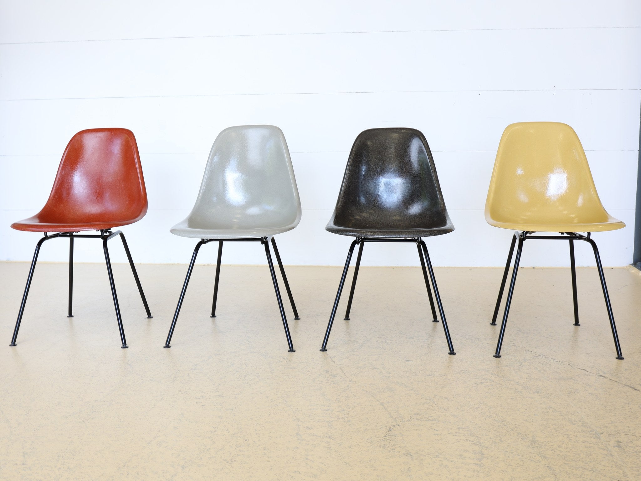 Vier Eames DSX Stühle Herman Miller verschiedene Farben Gruppenansicht