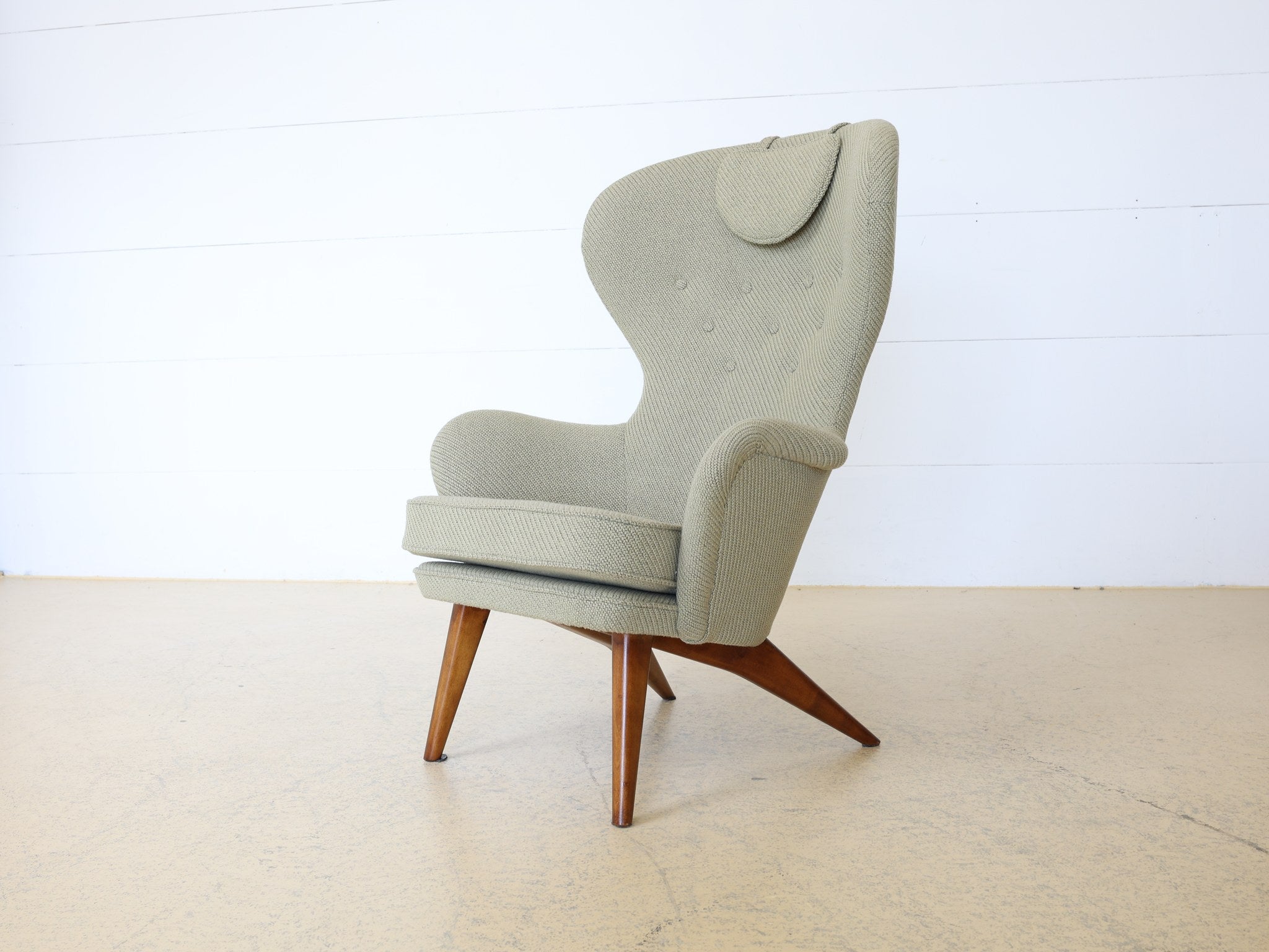 Handwerklich gefertigter Wingback Chair konische Beine Detailaufnahme