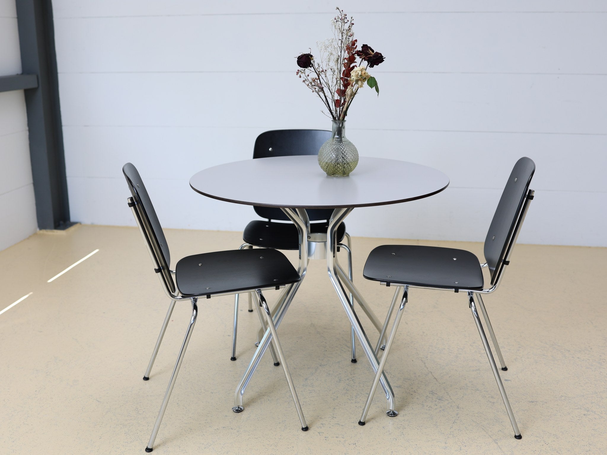 Schweizer Industrial Design Esstisch-Set mit Rundtisch und 4 Stapelstühlen in Schwarz-Chrom