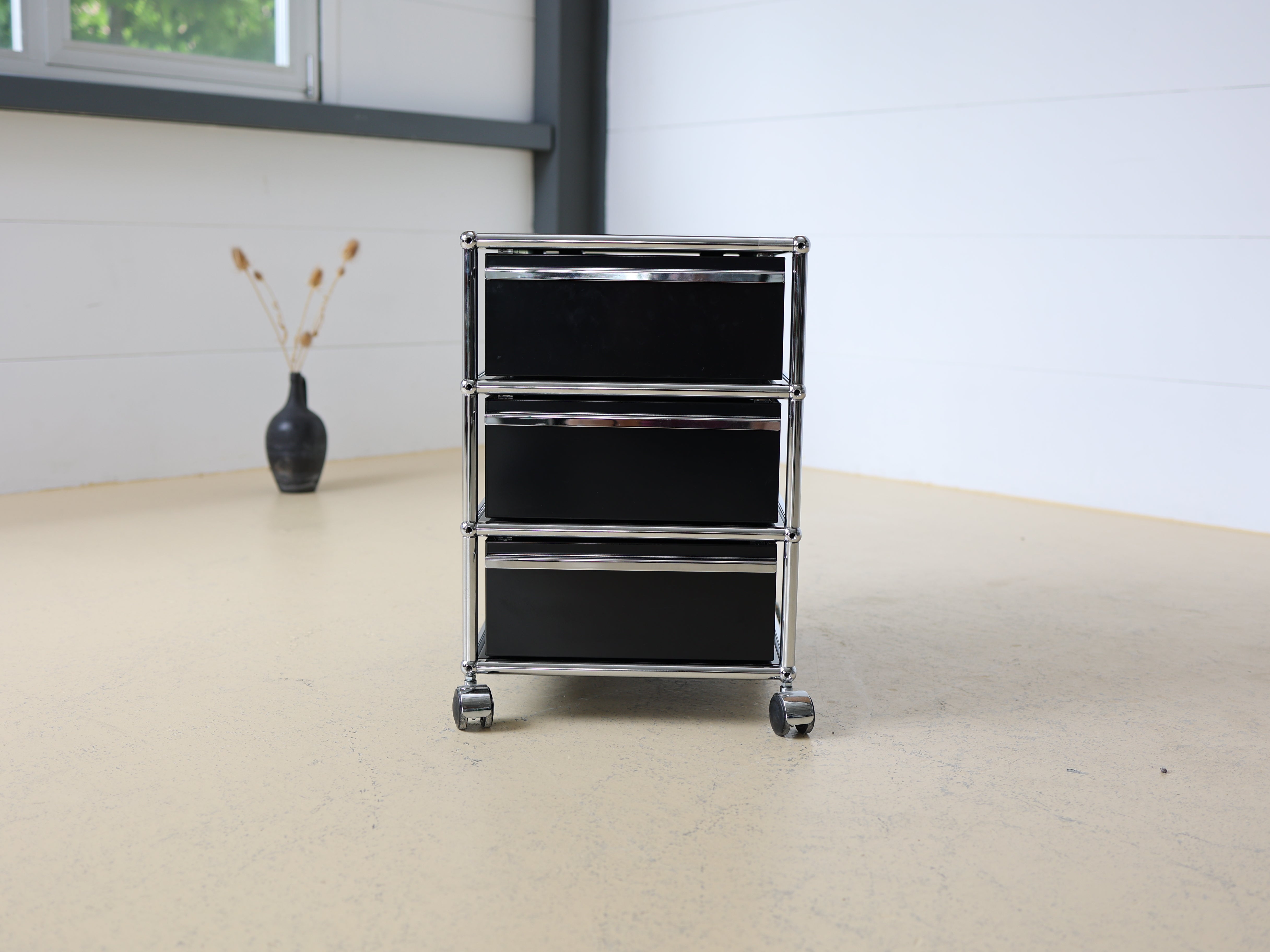 Schwarzer USM Haller Korpus und auf Rollen. Mobiler Bürocontainer als aufbereiteter und geprüfter Designklassiker bei atelier TILIJA.