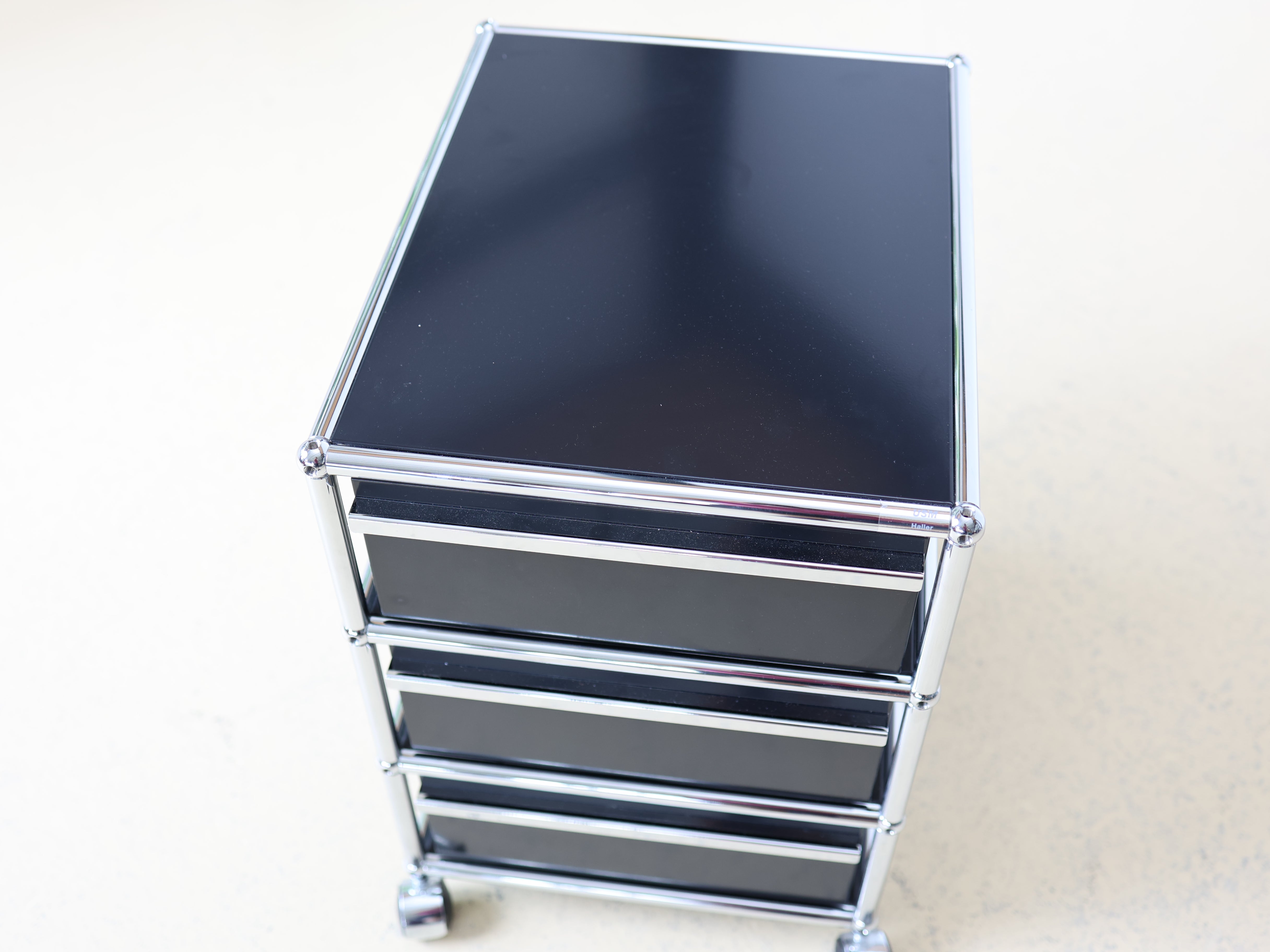 Schwarzer USM Haller Korpus und auf Rollen. Mobiler Bürocontainer als aufbereiteter und geprüfter Designklassiker bei atelier TILIJA.