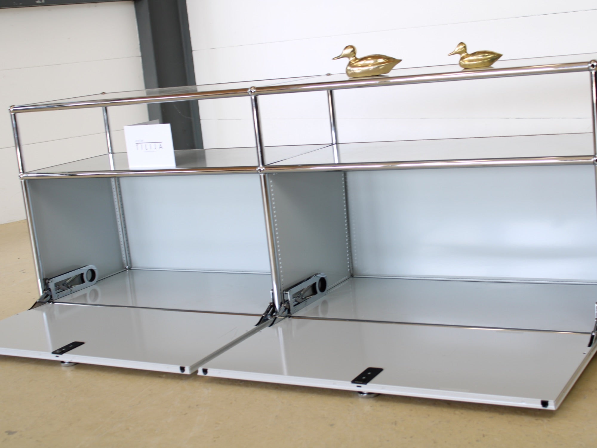 USM Haller Lowboard Vintage in Lichtgrau, mit zwei Klapptüren und 2 offen, tiefen Fächern. Modularer Schweizer Designklassiker im gepflegten Vintage-Zustand bei Atelier Tilija.