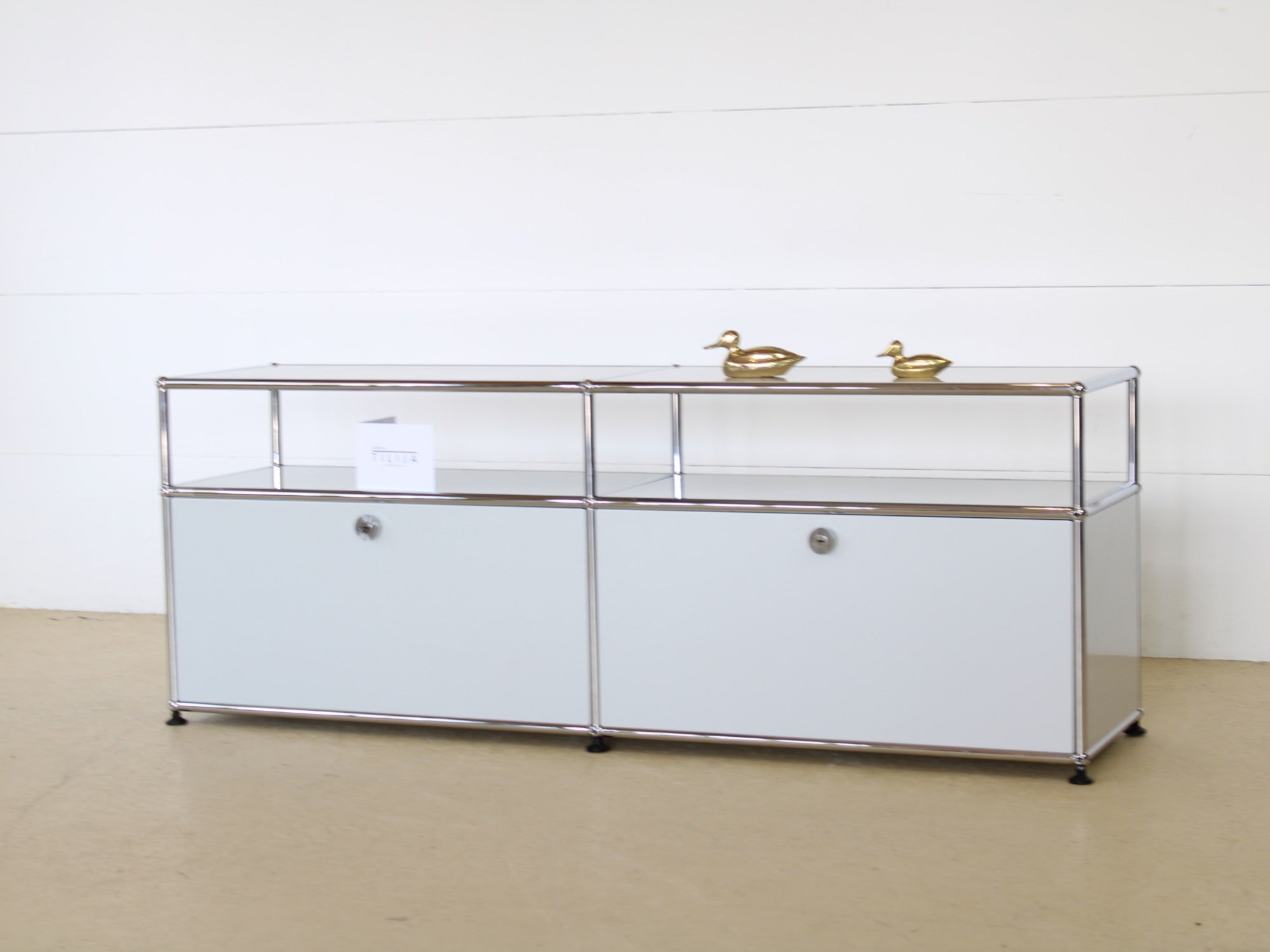 USM Haller Lowboard Vintage in Lichtgrau, mit zwei Klapptüren und 2 offen, tiefen Fächern. Modularer Schweizer Designklassiker im gepflegten Vintage-Zustand bei Atelier Tilija.