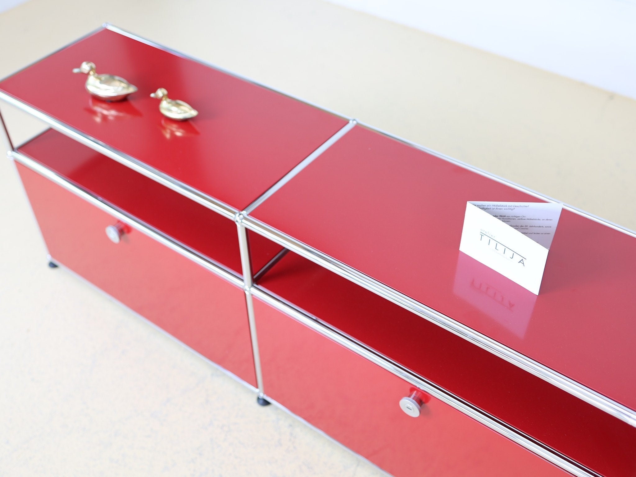 USM Haller Sideboard in Rubinrot, seitliche Perspektive mit offenem Fach