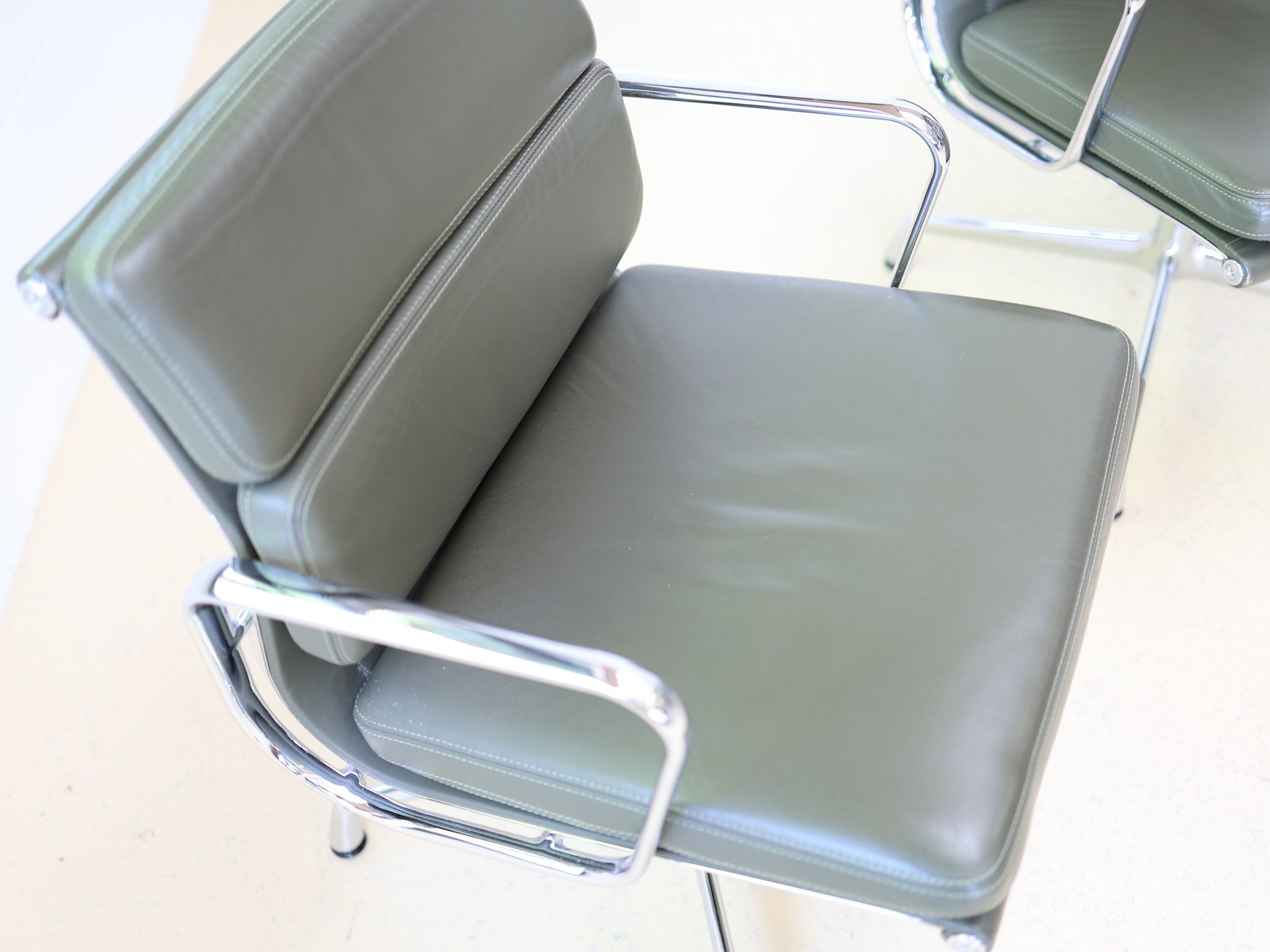Vitra Eames Soft Pad EA 208 4er Set Konferenzstühle in olivgrünem Leder Frontalansicht