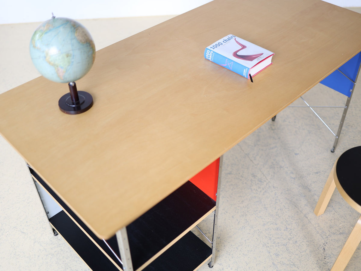Eames Desk Unit EDU, Vitra – Gesamtansicht mit offenen Ablageböden in Schwarz und Farbverkleidungen Rot und Blau
